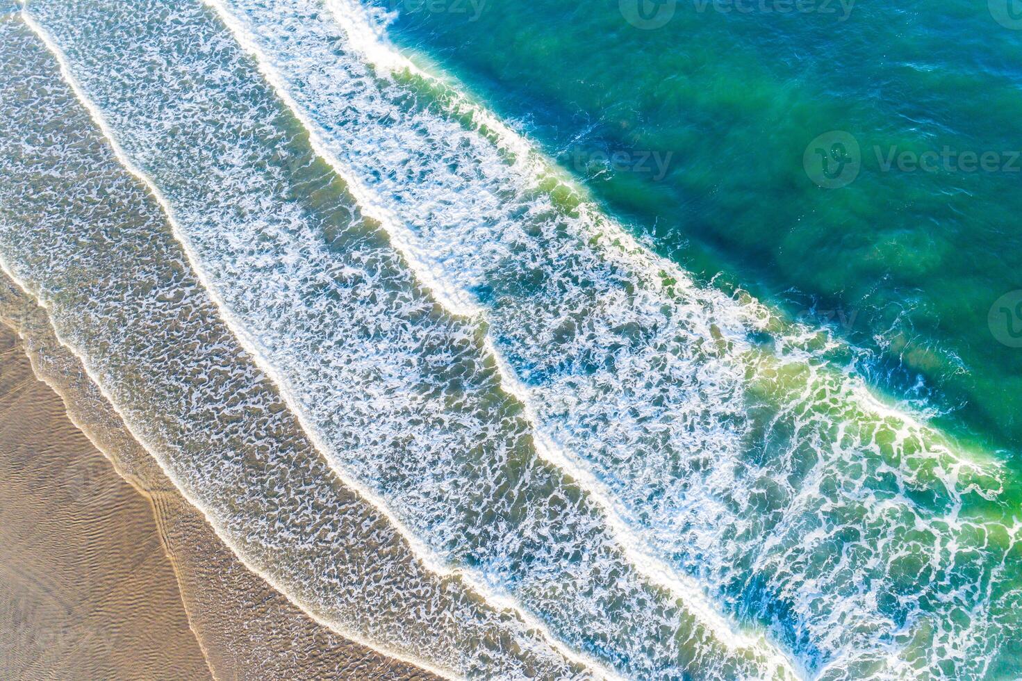 zenithal aerial view with drone of the waves of a beach at sunrise, background for summer concept photo