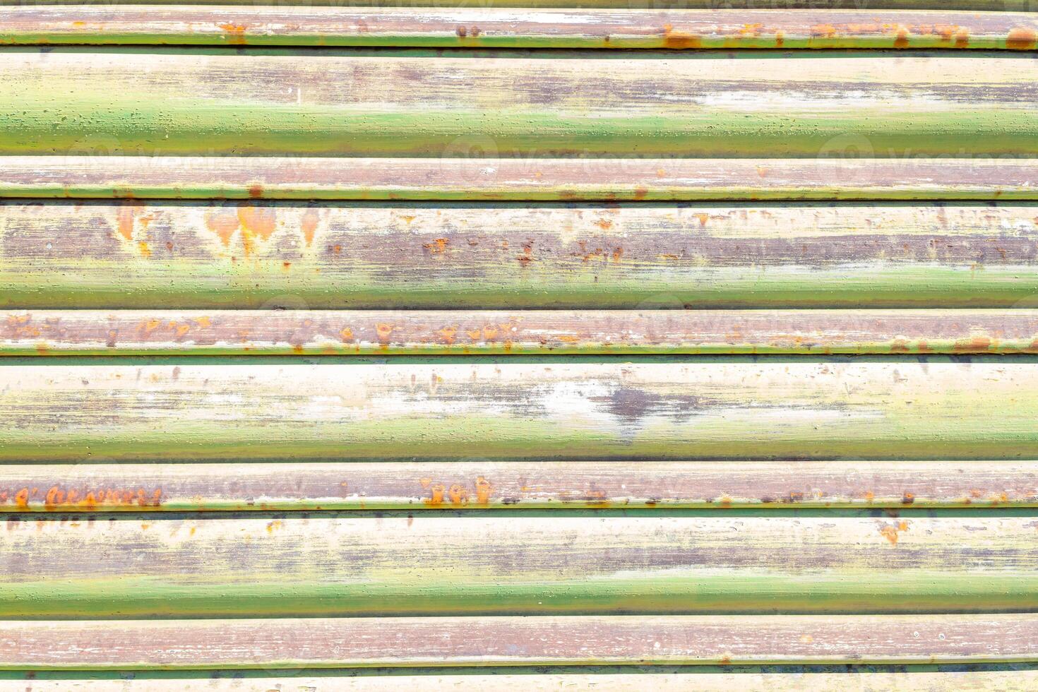 close up view of an old, rusted metal shutter with traces of green paint, textured background photo
