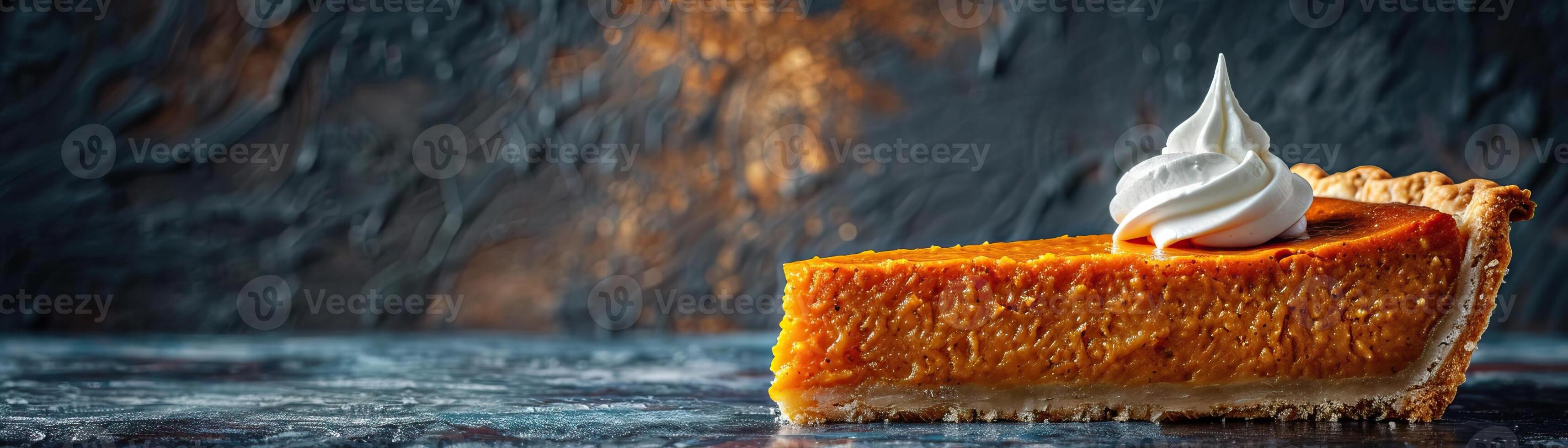 A minimalist composition featuring a piece of pumpkin pie with a perfect peak of whipped cream, set against a dark, textured backdrop, panoramic space above for copy. photo