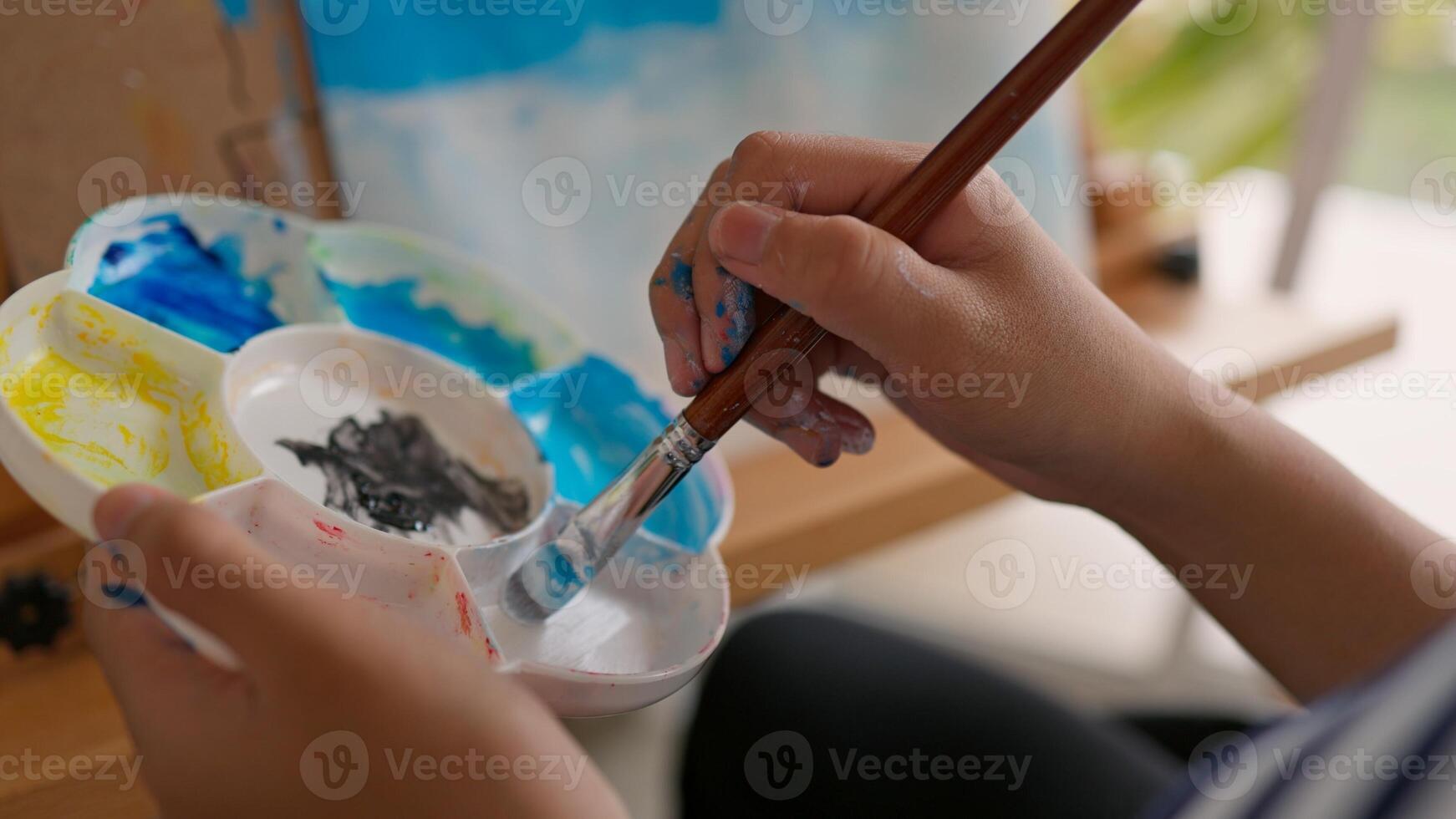 A girl is painting a picture on a canvas photo