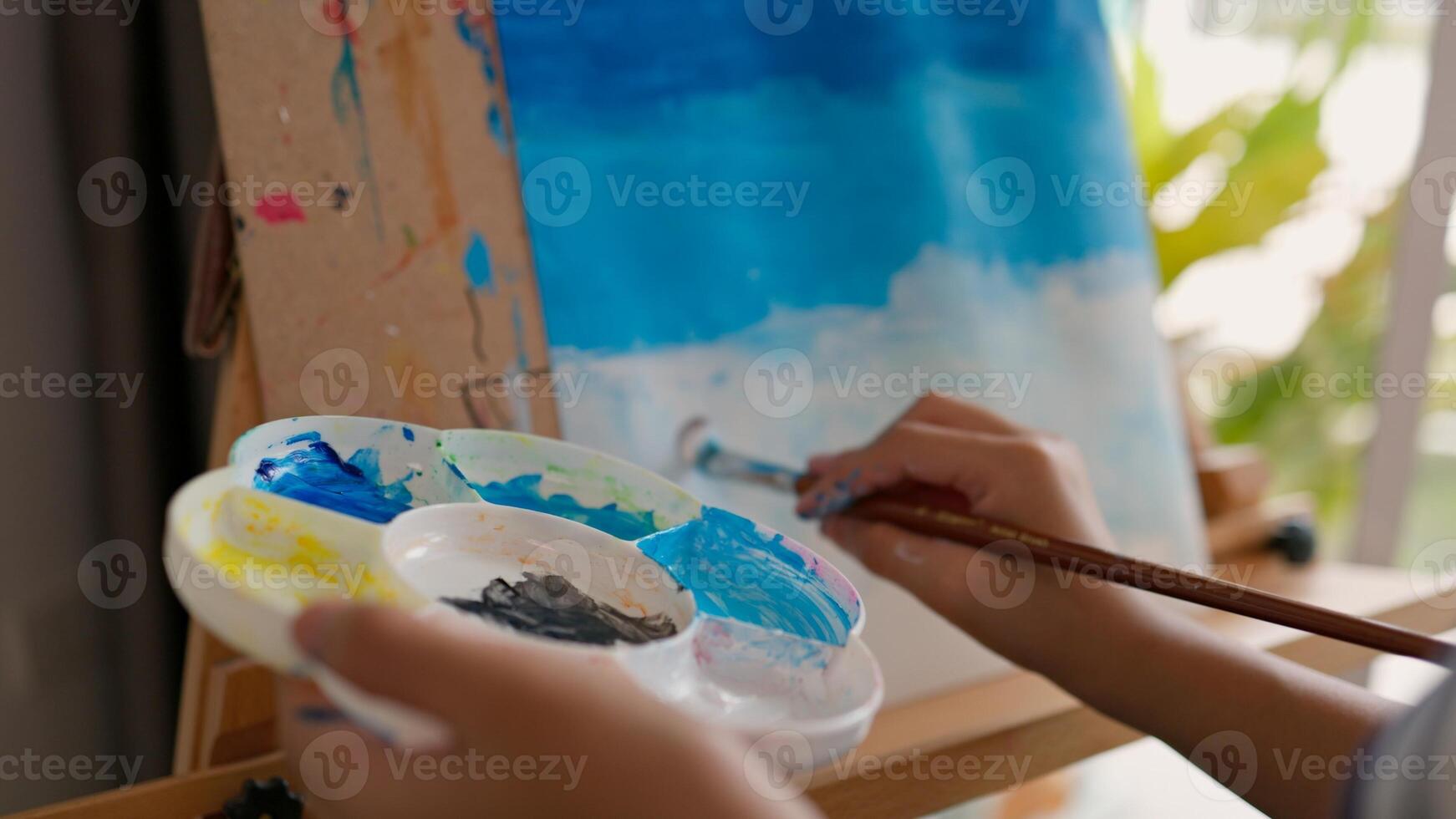 A girl is painting a picture on a canvas photo