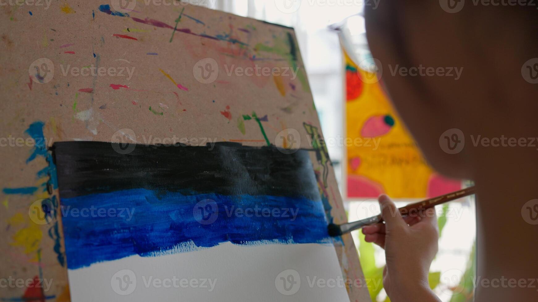 A girl is painting a picture on a canvas photo