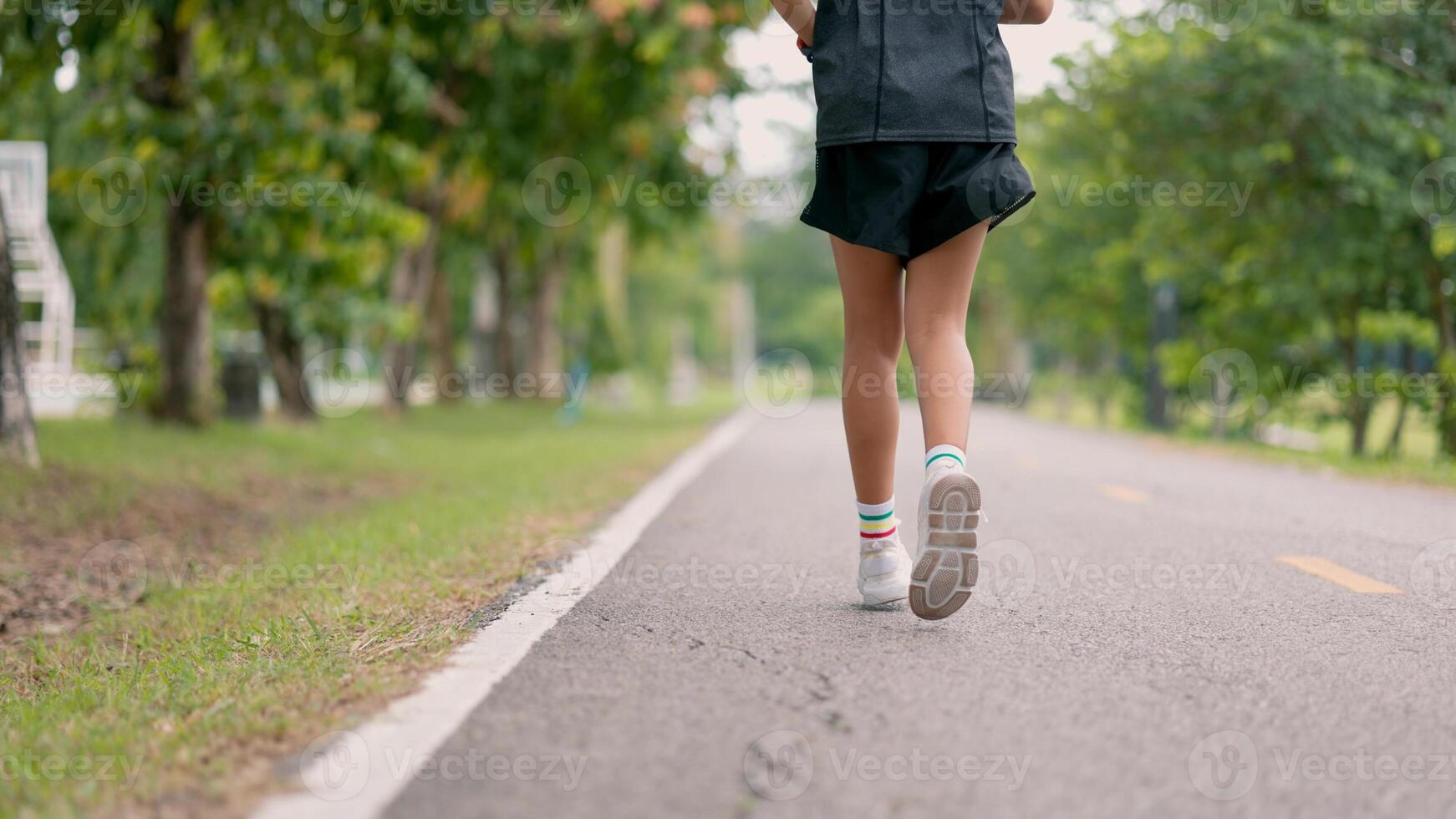 A young girl is running on a road with a pair of white sneakers photo