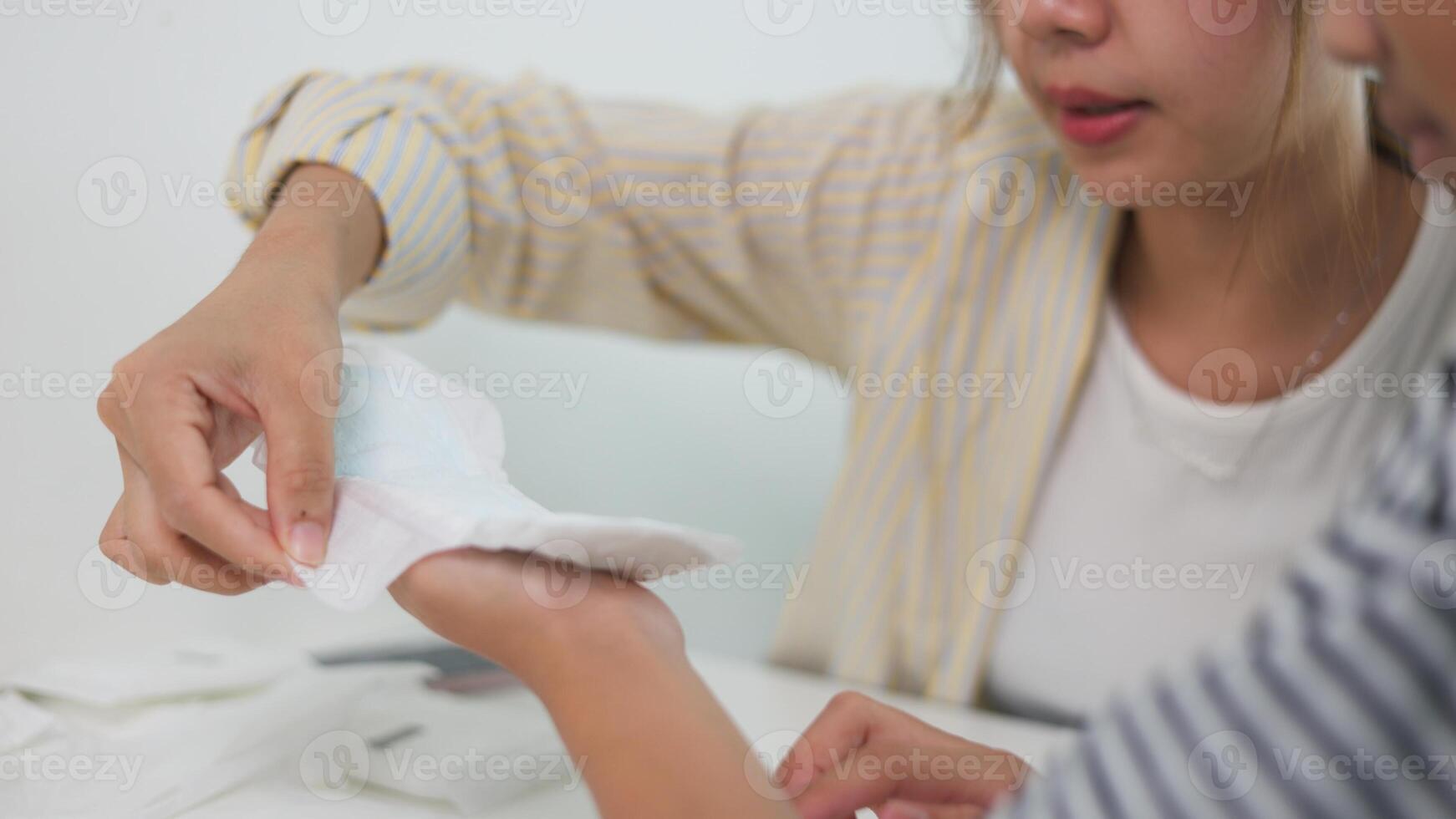 Women and siblings study how to use sanitary napkins, focusing on health concepts. photo