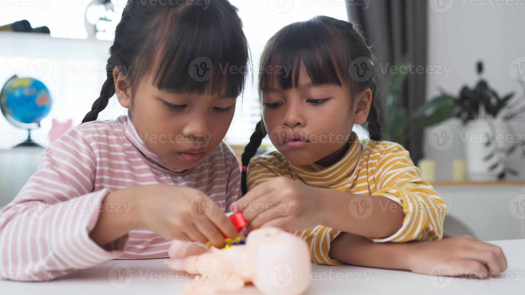 Asian girl playing with anatomical dolls in a doctor game, Learn through play about internal organs with anatomical dolls at home. Children want to be a doctor. photo