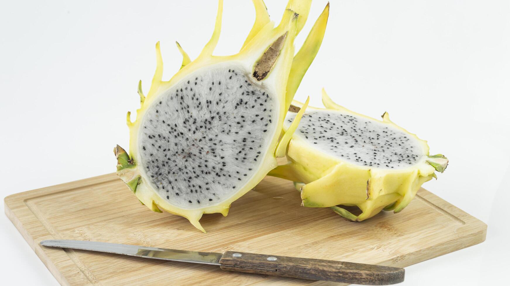 a dragon fruit on a cutting board with a knife photo
