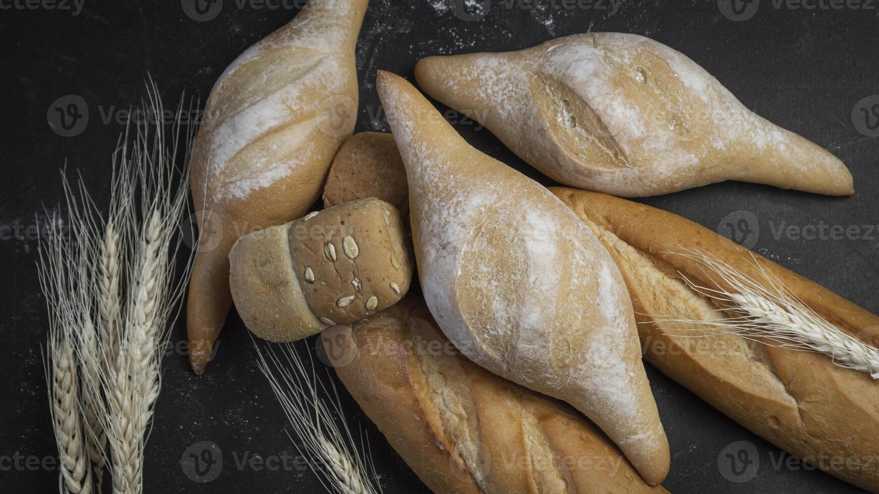 bread and wheat on a black background photo