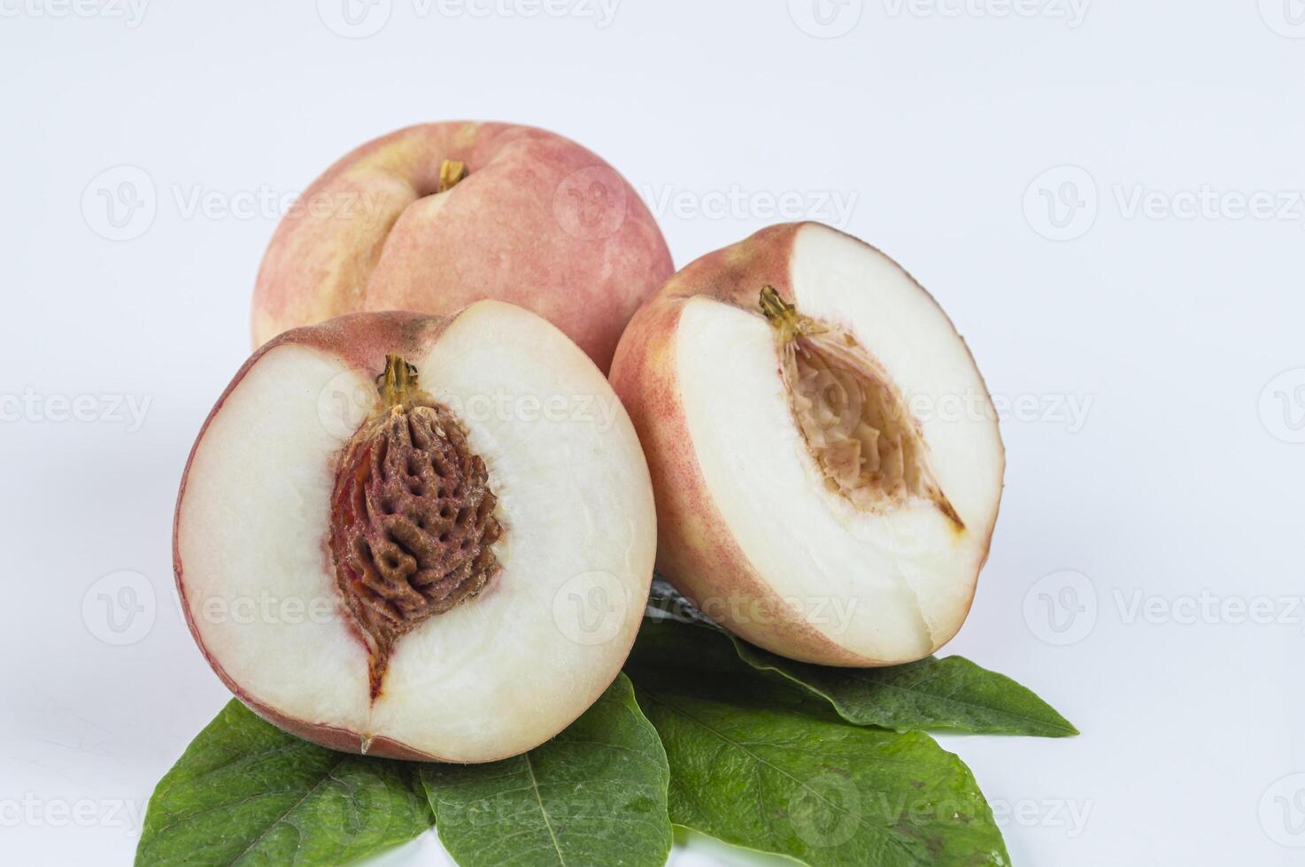 peach with green leaves on white background photo
