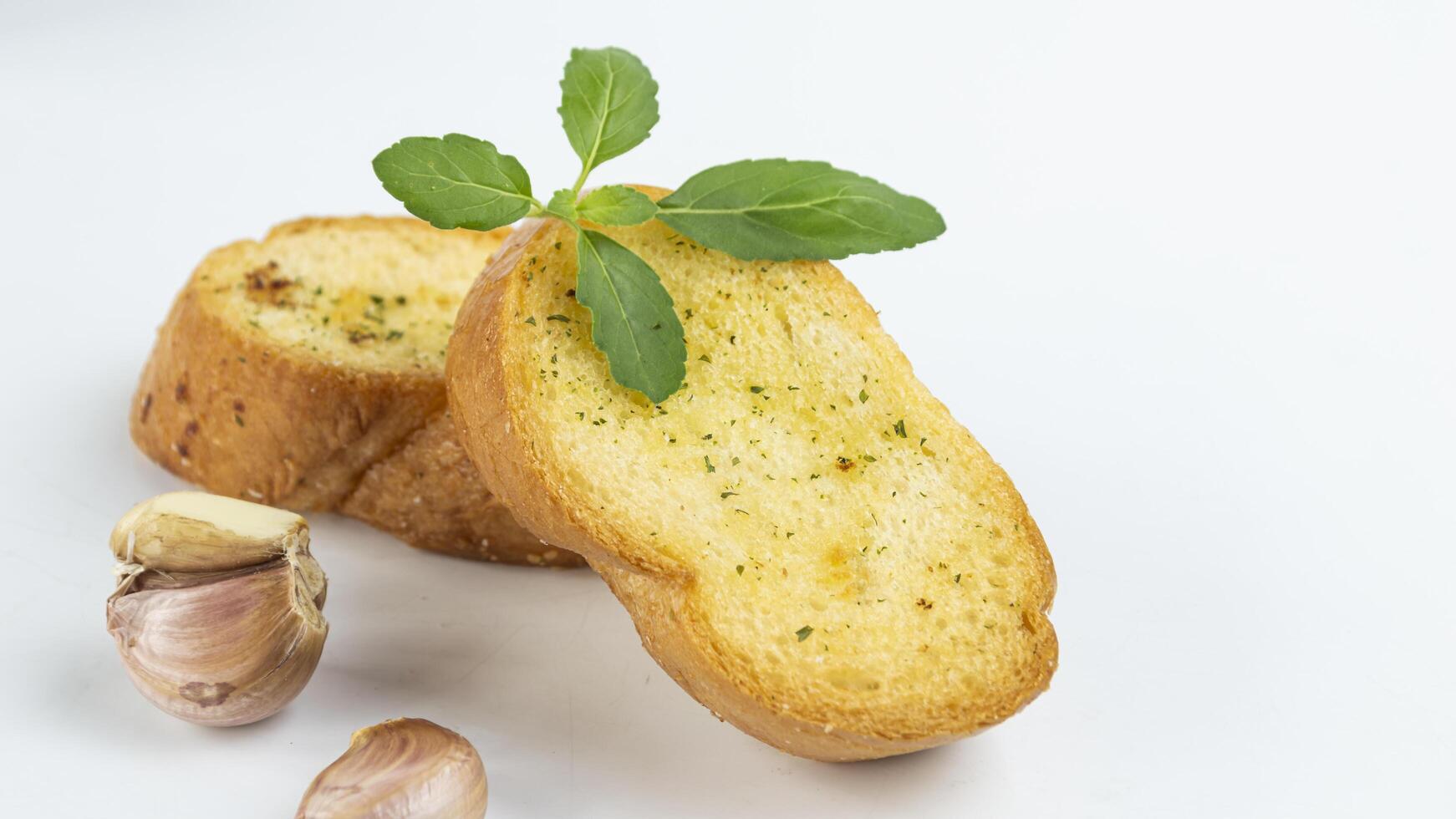 garlic bread with garlic and parsley on white background photo