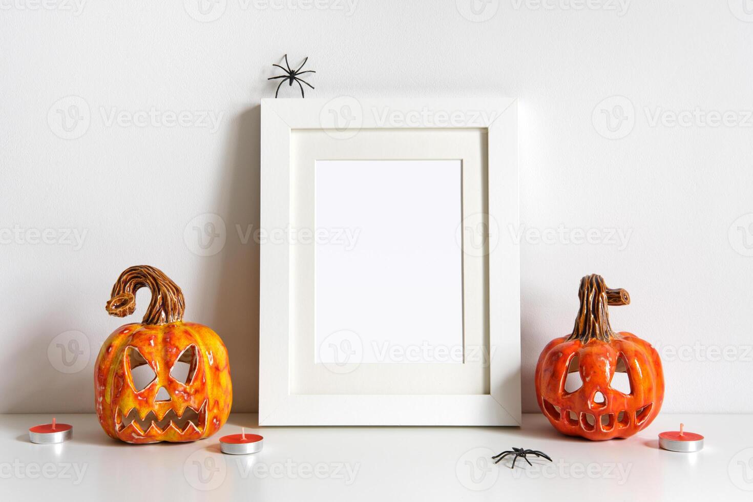 Halloween composition with ceramic pumpkins jack lantern and frame on table wall background. Greeting card template photo