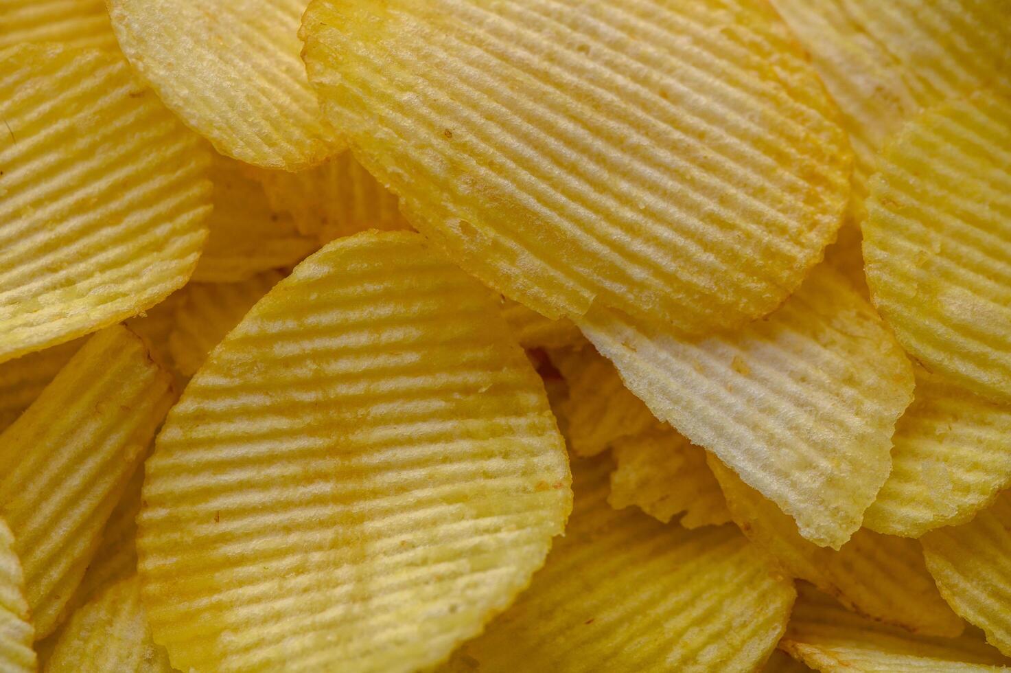 Crispy potato chips snack texture background. Top view. Flat lay photo