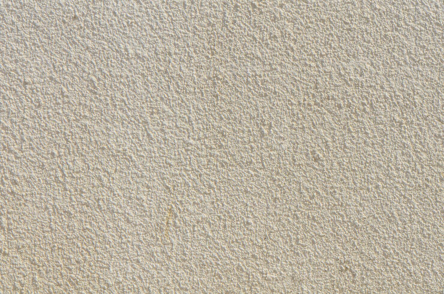 Freestone wall covered with weathered and worn cement and sidewalk photo