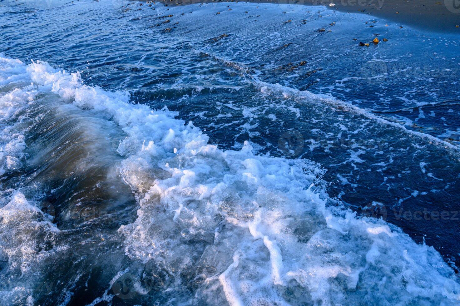 Abstract blue water background with sun reflection and ripples photo