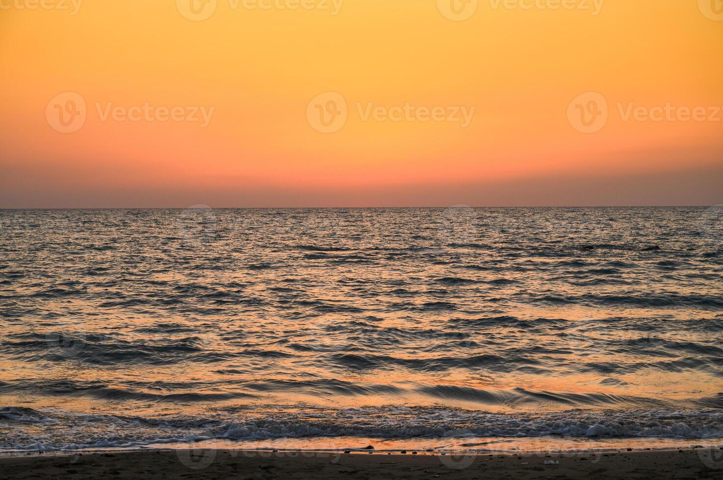The sky is orange and the sun is setting photo