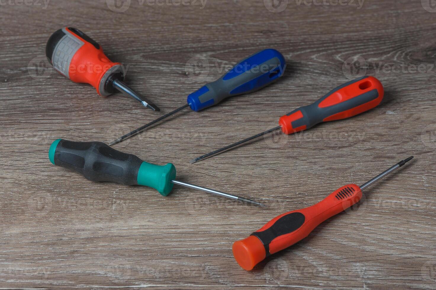 Set of screwdrivers and screws on wooden table, flat lay. Space for text photo