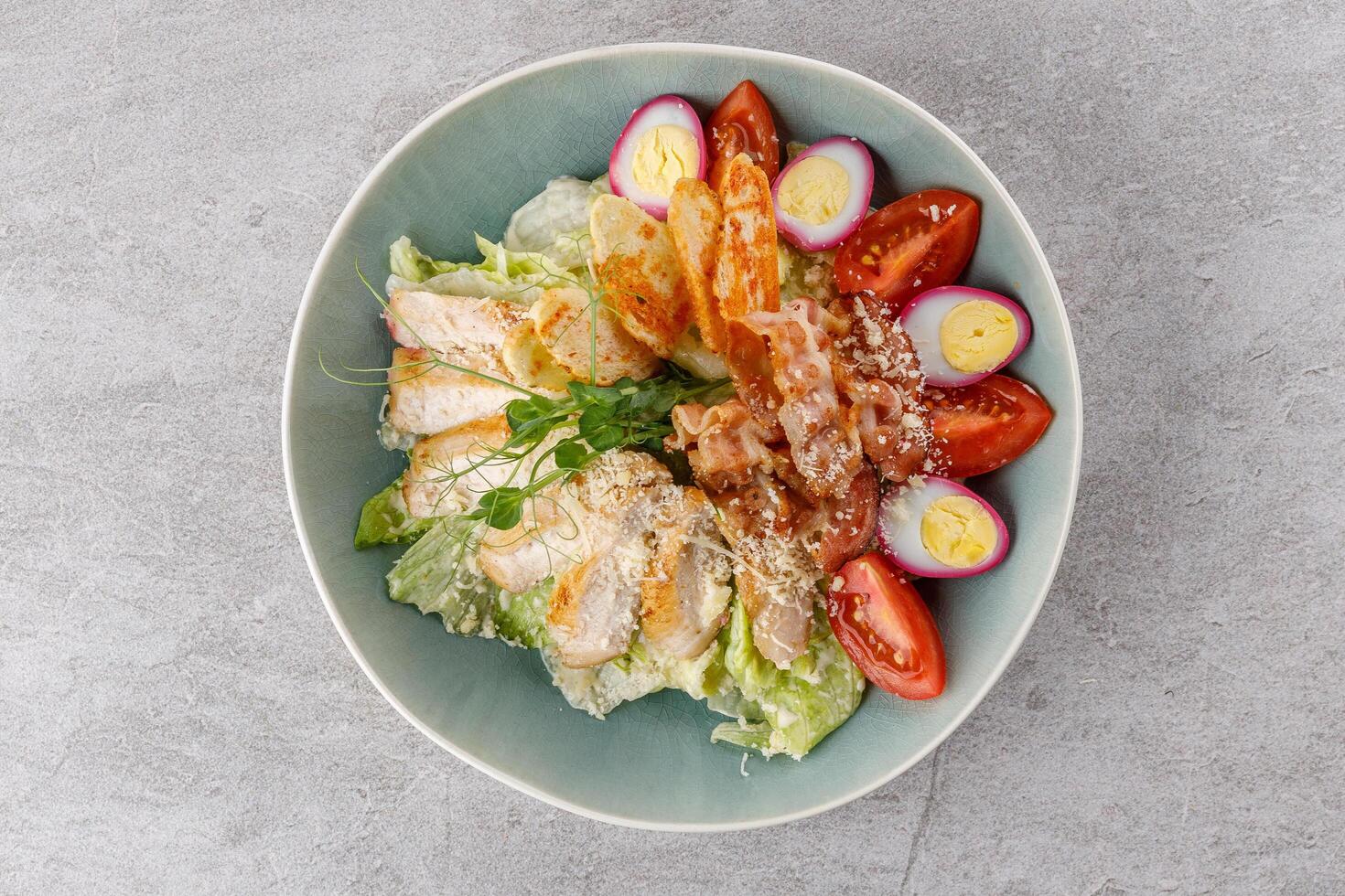 Caesar salad with chicken and bacon on a stone background studio food photo 4