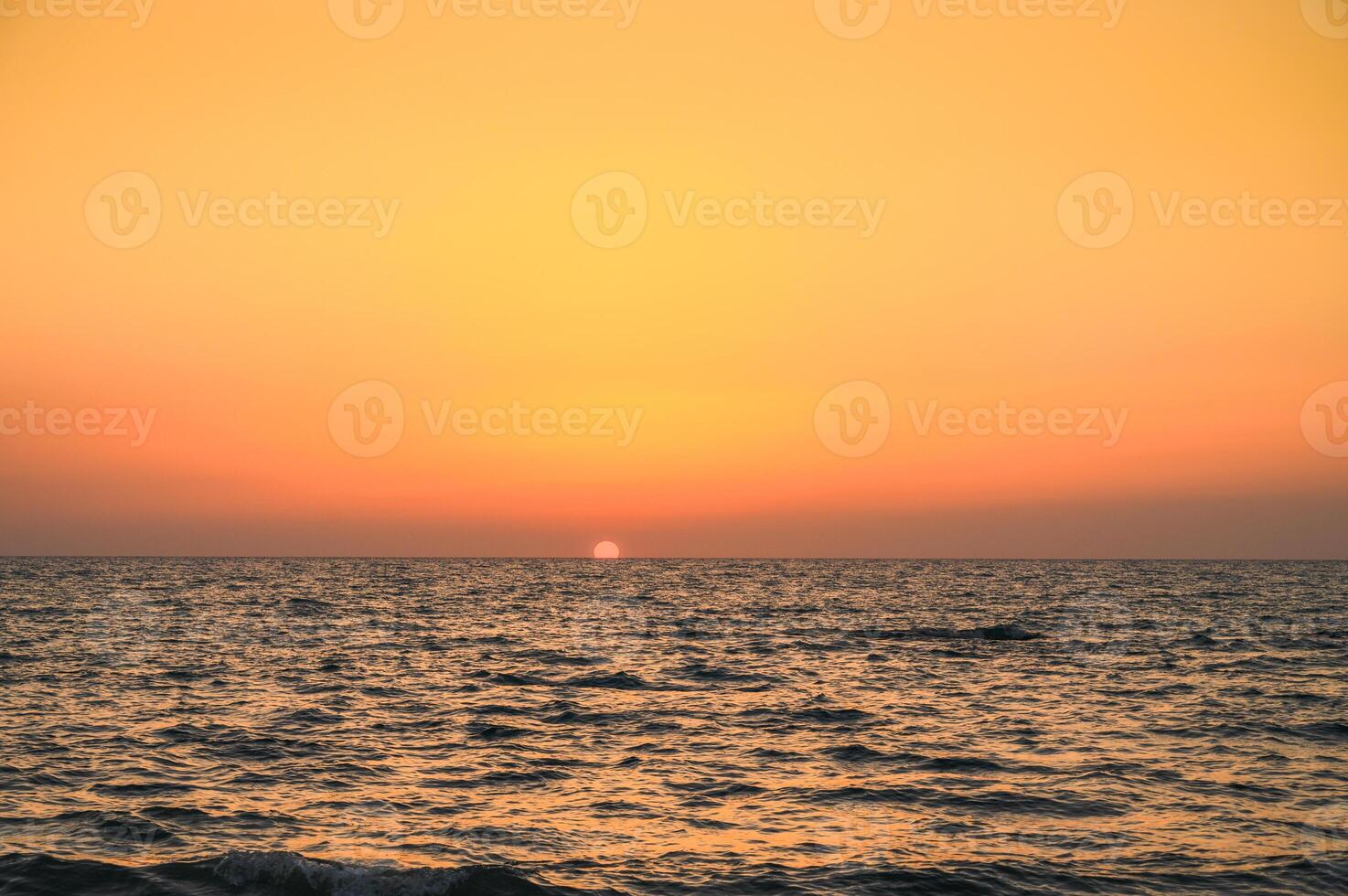 Golden hour shot of the sun setting over the Mediterranean Sea photo