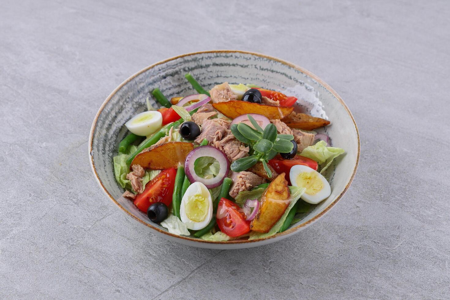salad with tuna, quail eggs and baked potatoes on a stone background, studio food photography 4 photo