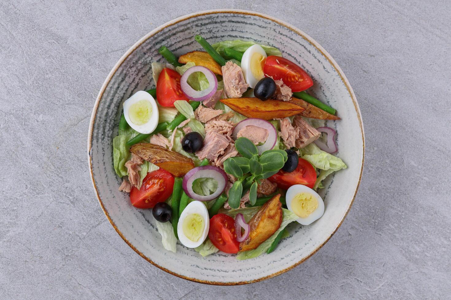salad with tuna, quail eggs and baked potatoes on a stone background, studio food photography 2 photo