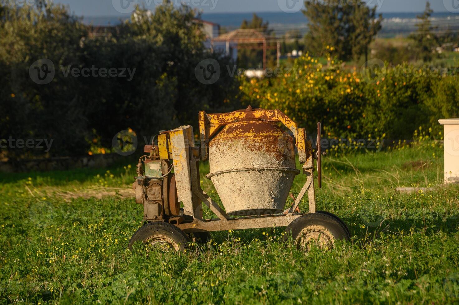 an old concrete mixer stands in the garden 1 photo