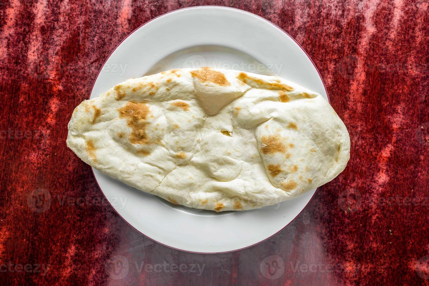Plain Naan or sada khamiri roti served in plate isolated on table background top view of bangladeshi, indian and pakistani food photo