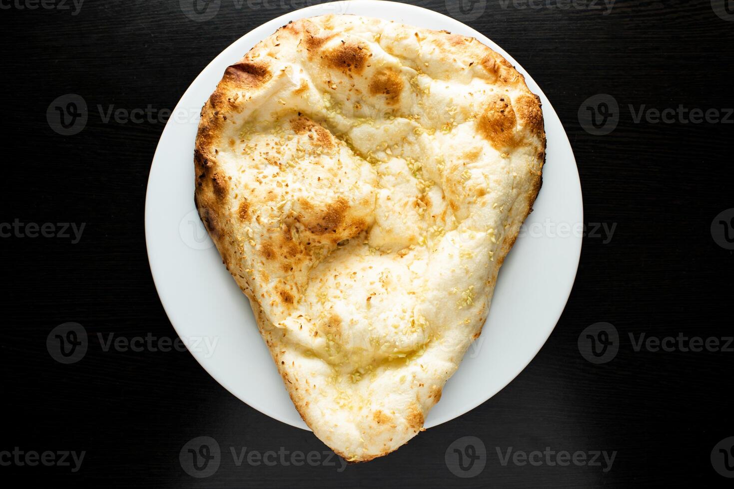Tandoori Garlic Naan, nan, nun, bread or roti served in dish isolated dark background top view of indian spices, bangladeshi and pakistani food photo