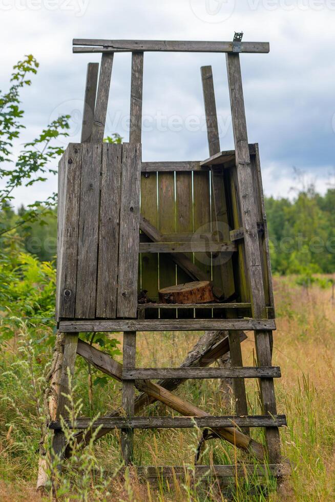 wooden hunting structure with a ladder and a bench photo