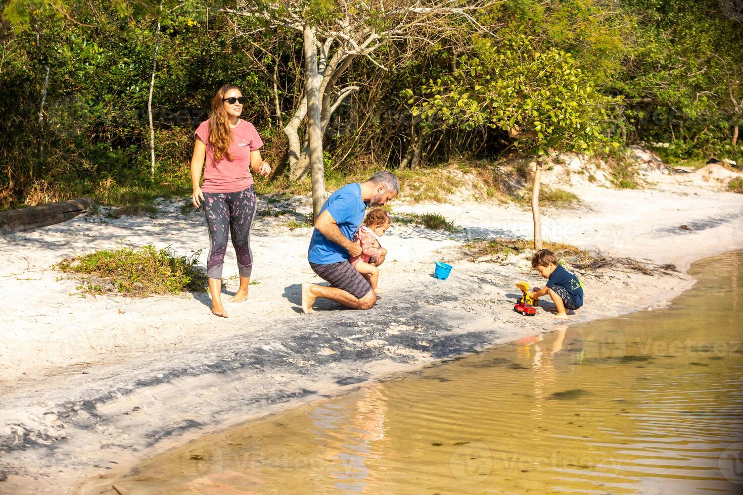 Young caucasian family having a picnic at the lake on a sunny afternoon. photo
