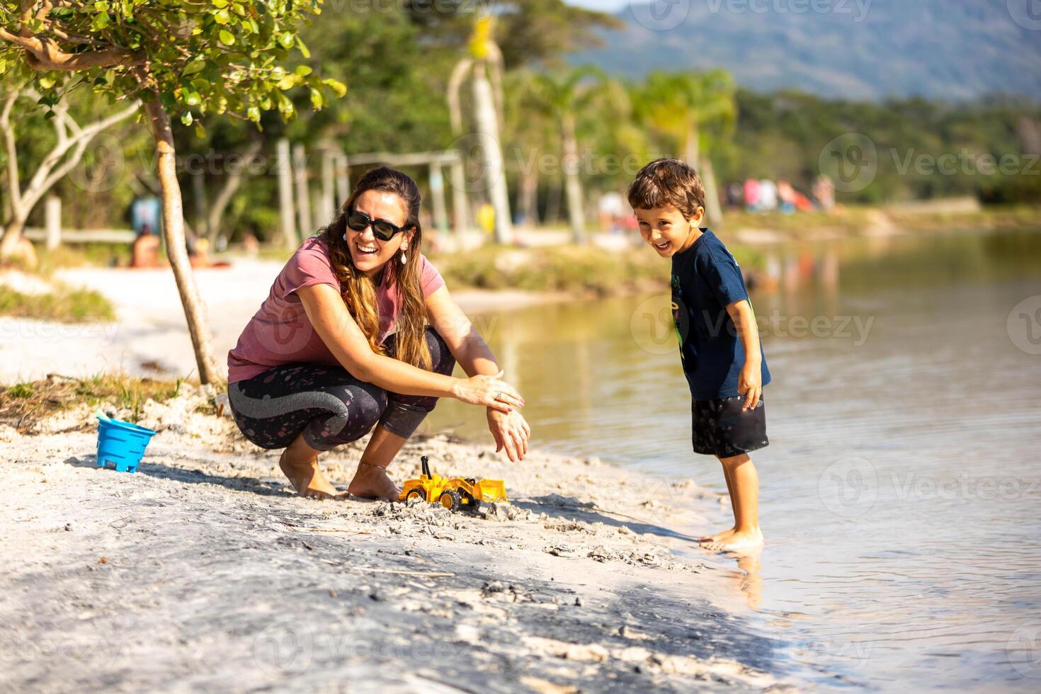 Young caucasian family having a picnic at the lake on a sunny afternoon. photo