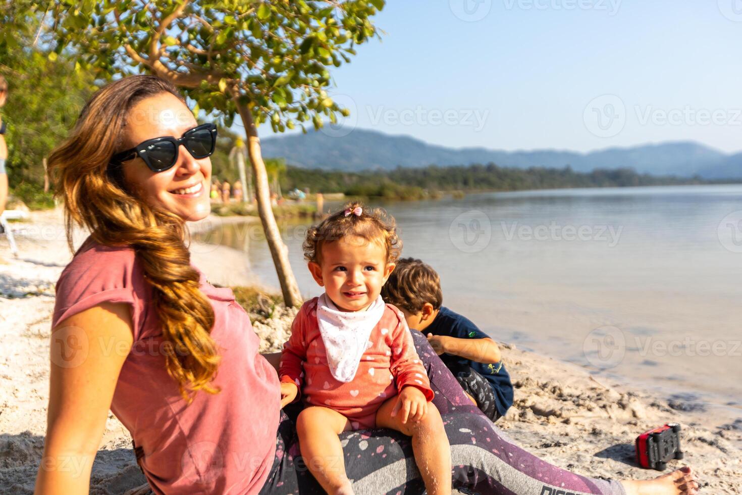 Young caucasian family having a picnic at the lake on a sunny afternoon. photo