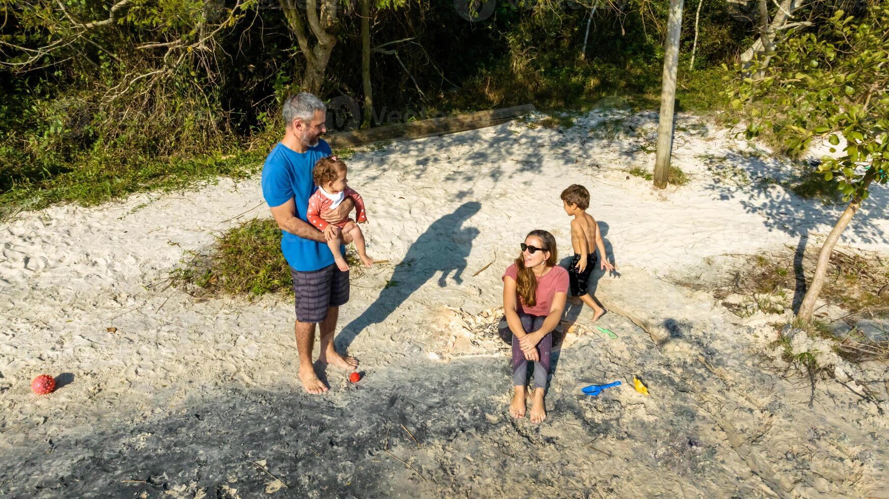 Young caucasian family having a picnic at the lake on a sunny afternoon. photo