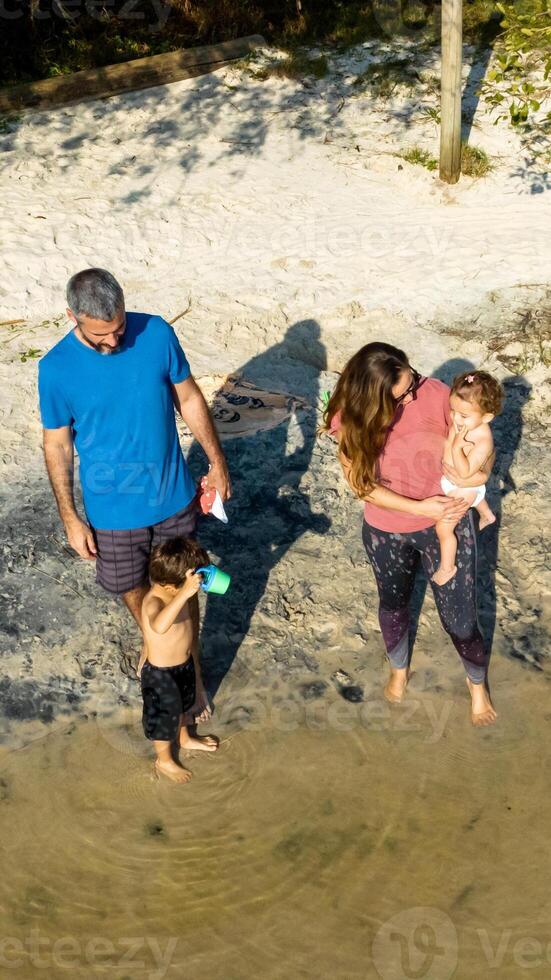 Young caucasian family having a picnic at the lake on a sunny afternoon. photo