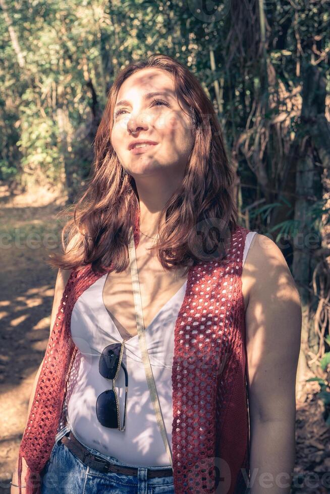Brazilian woman enjoys the sun when she take a walk in the Botanical garden. Jardim Botanic Garden, Sao Paulo, Brazil. photo