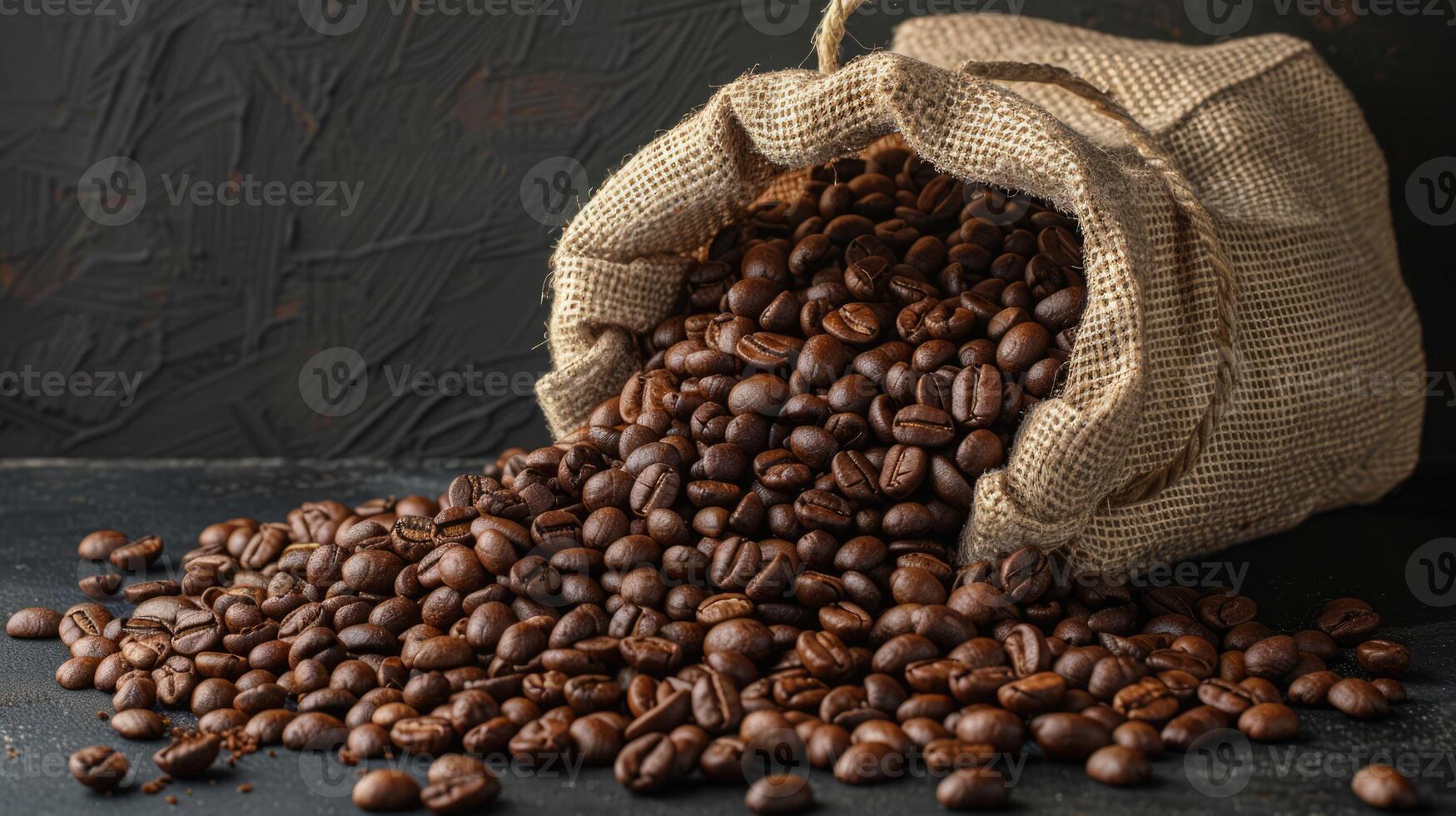 Roast coffee beans spilled out of a burlap sack onto a black table on dark background photo