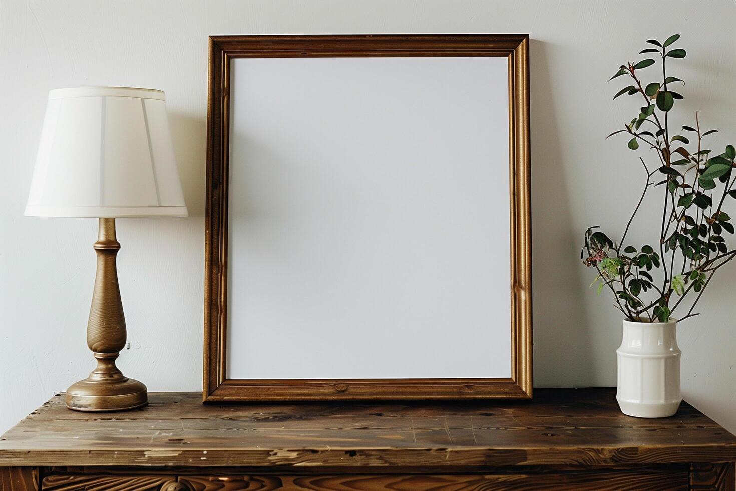 a wooden table with a blank white canvas with wood frame and a lamp photo