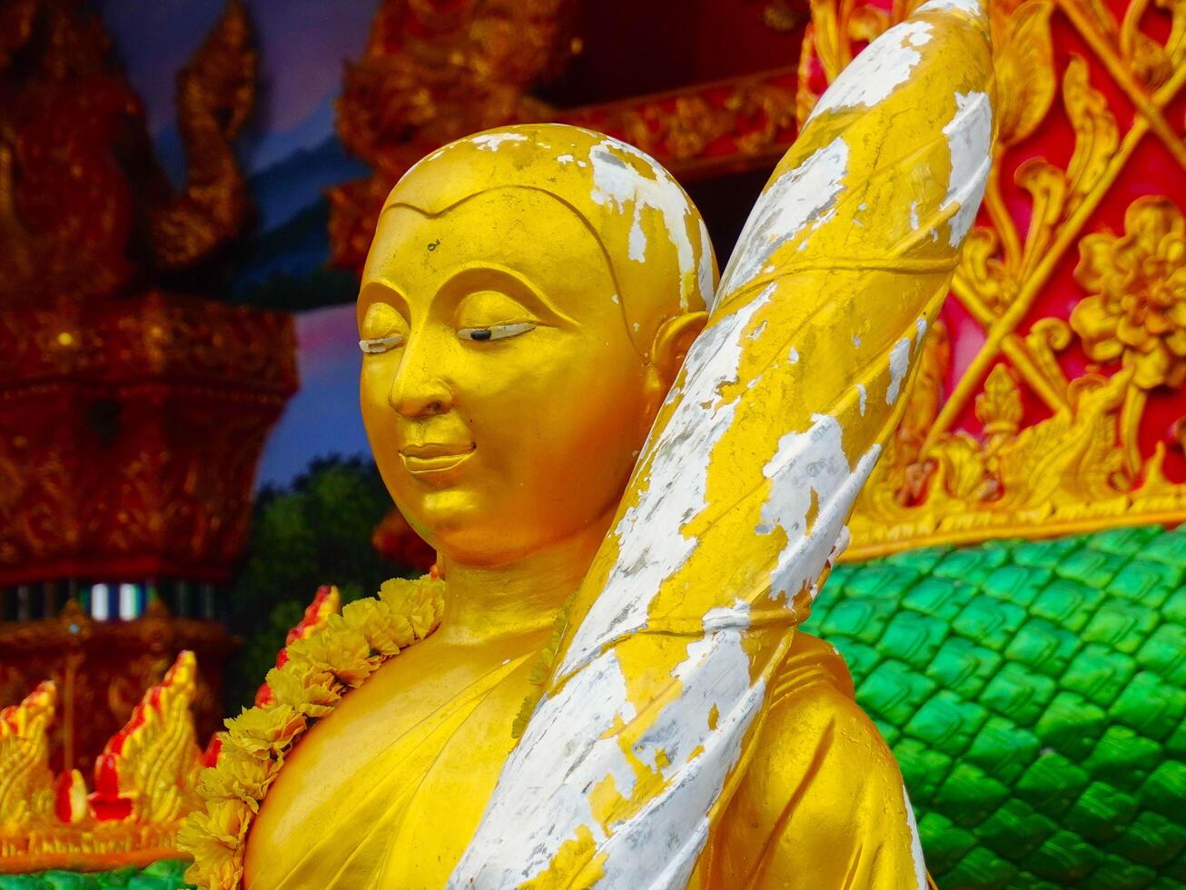 Golden Buddha statues and sculptures at Wat Sapan in the middle of a valley surrounded by nature in Nan Province, Thailand. photo
