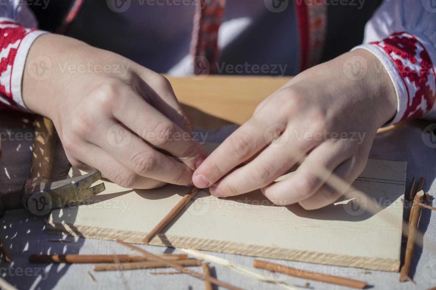 The hands of an artisan make a craft from straw. Hand made product photo