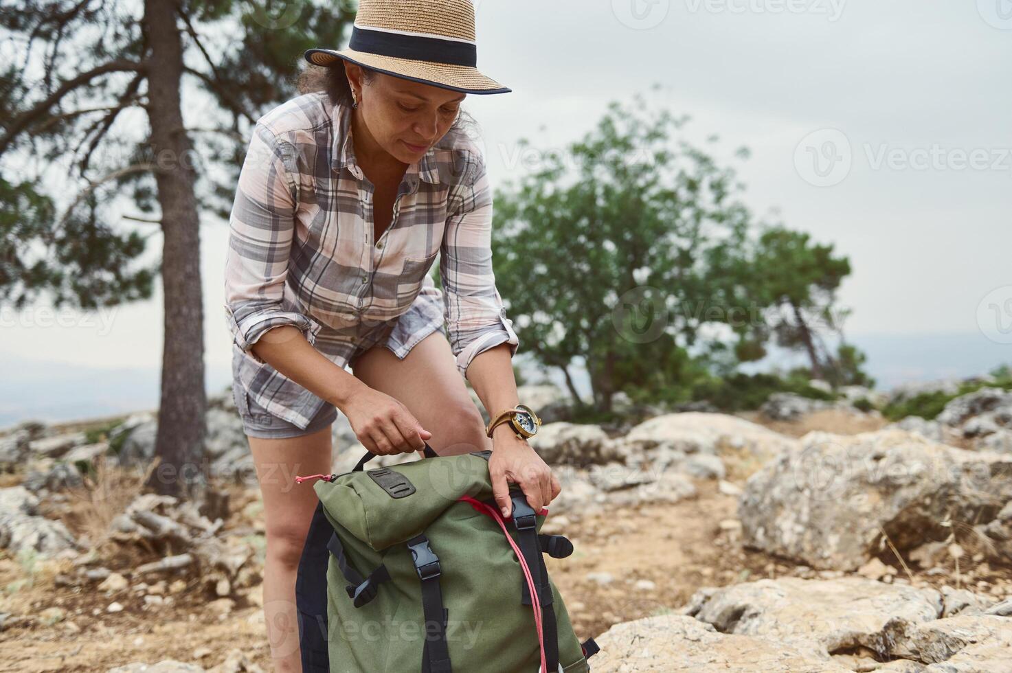 Woman preparing for a hike in nature with a green backpack photo
