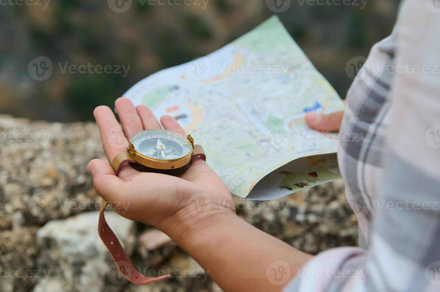Traveler holding a compass and map, exploring the outdoors photo