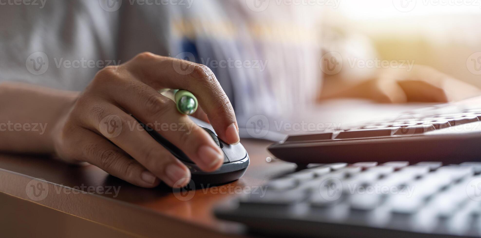 Closeup shot of a mouse holding a female hand and working with a desktop computer while sitting at a desk. photo