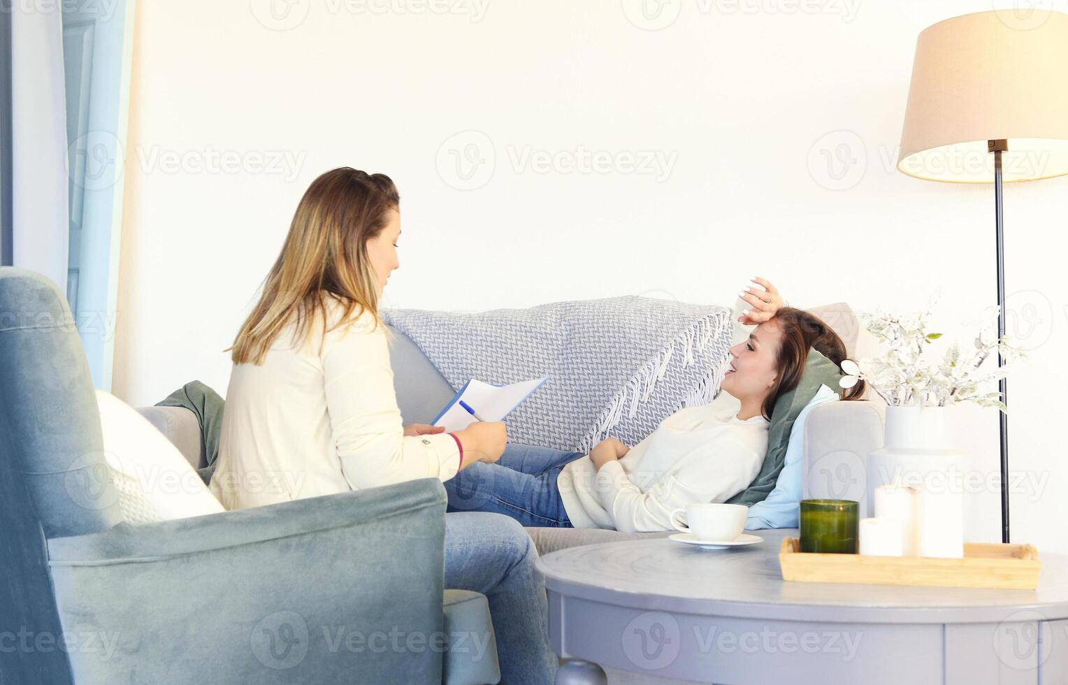 Smiling woman on couch talking with therapist photo