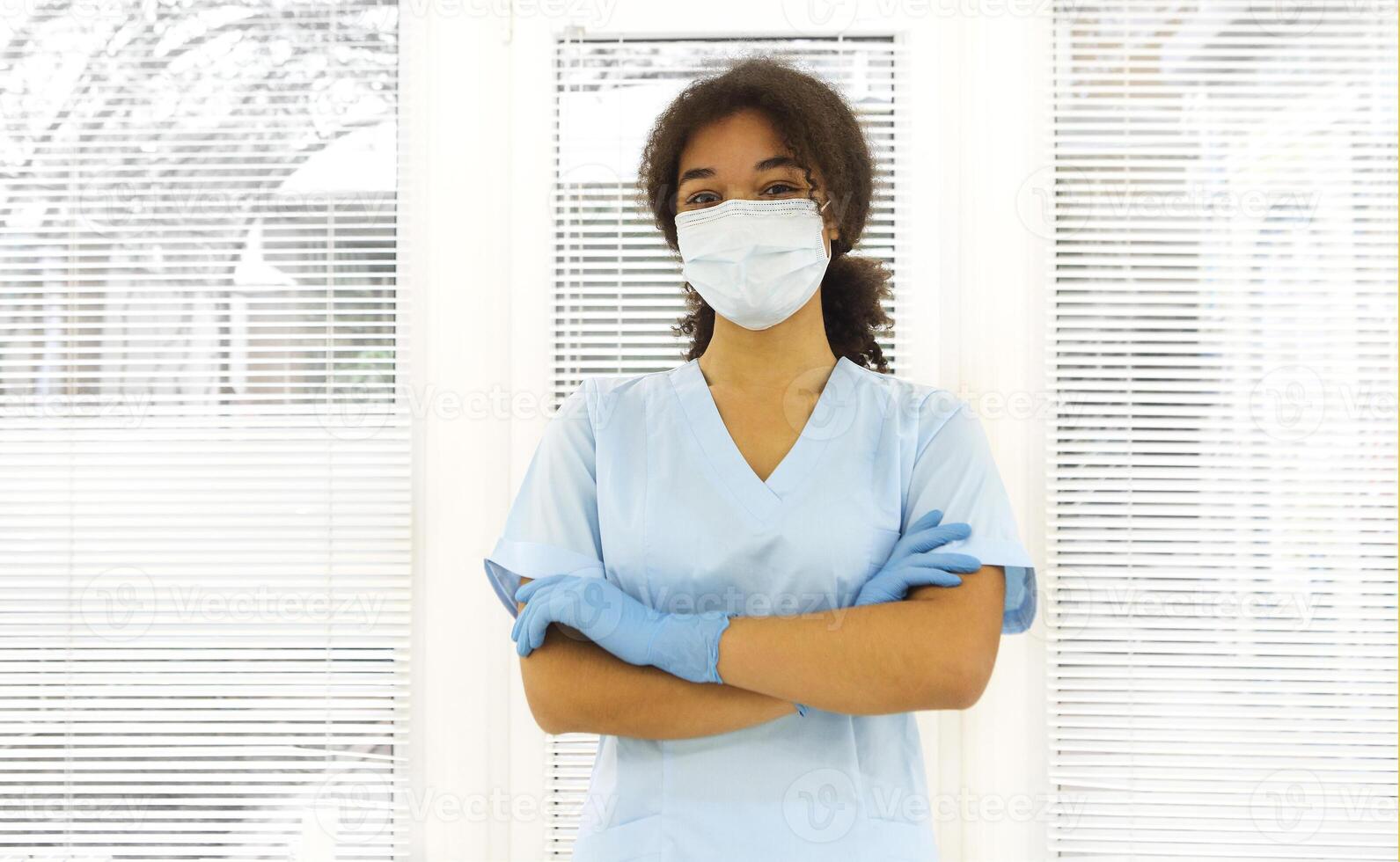 Young tired overworked african american medical worker wearing protective face mask photo