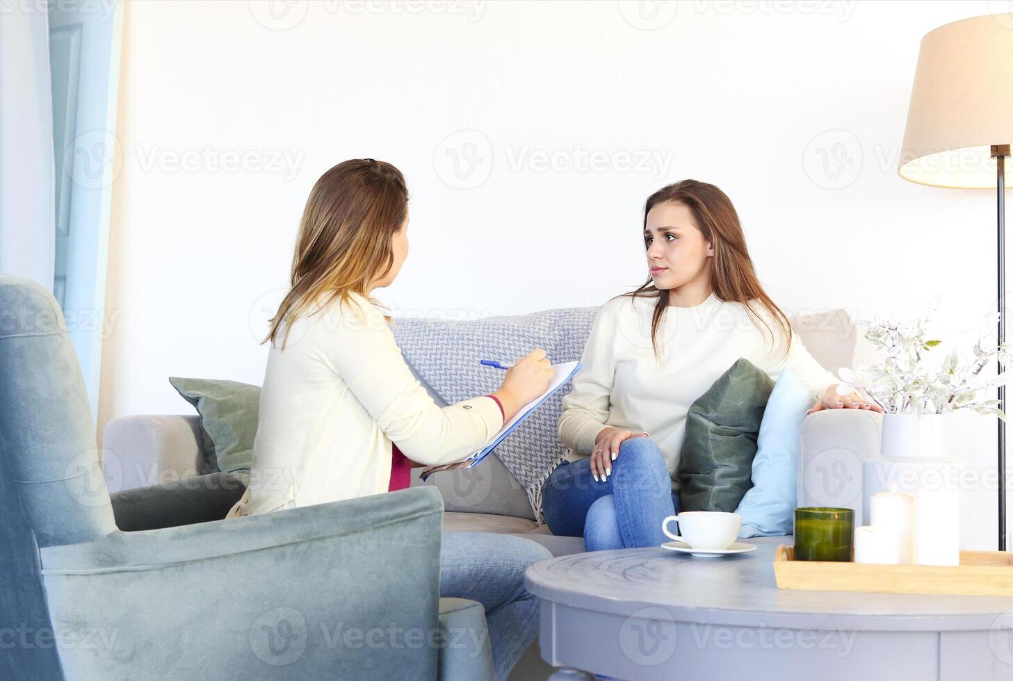 Smiling woman on couch talking with therapist photo