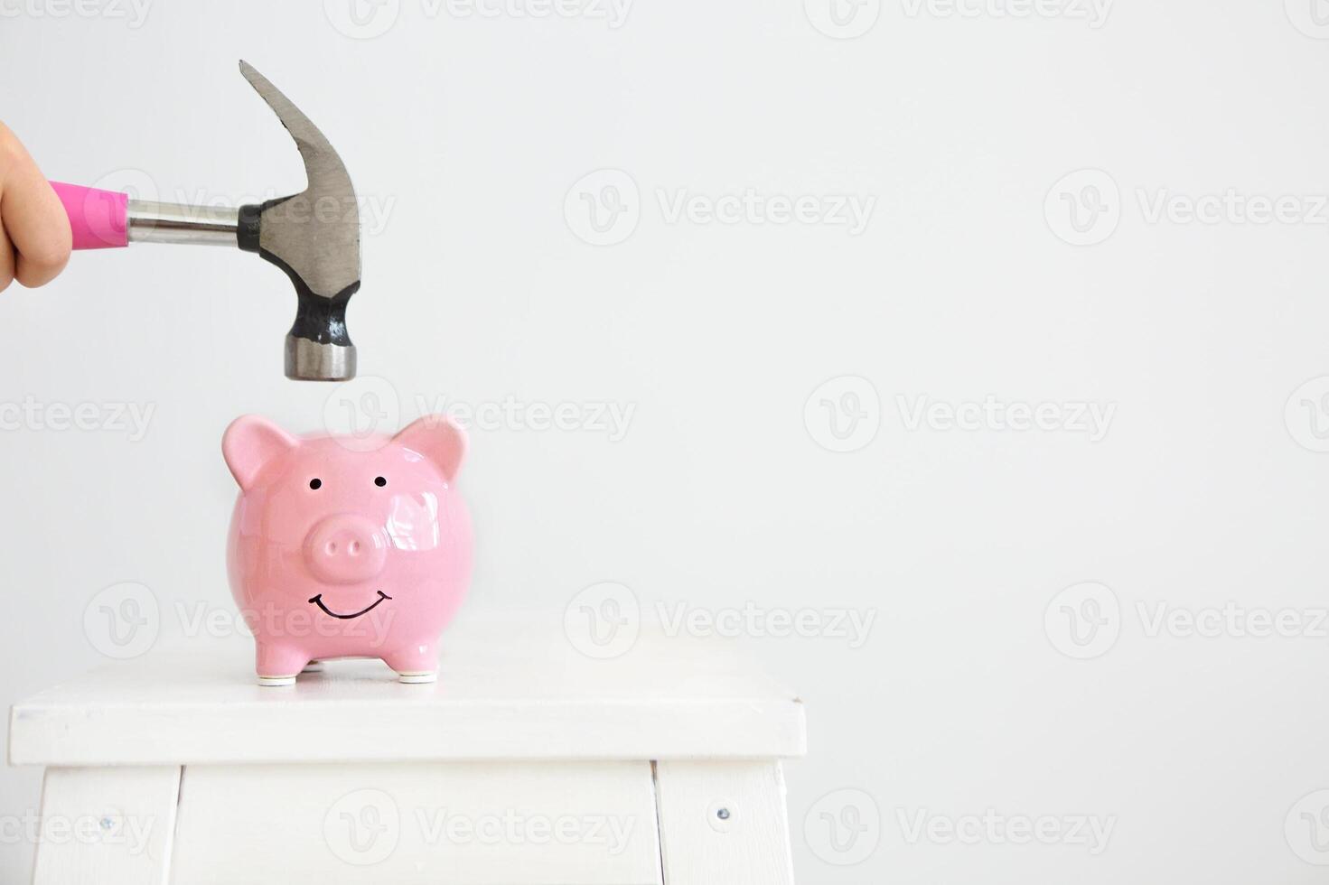 Pink pig piggy Bank and hammer under it on a white background photo