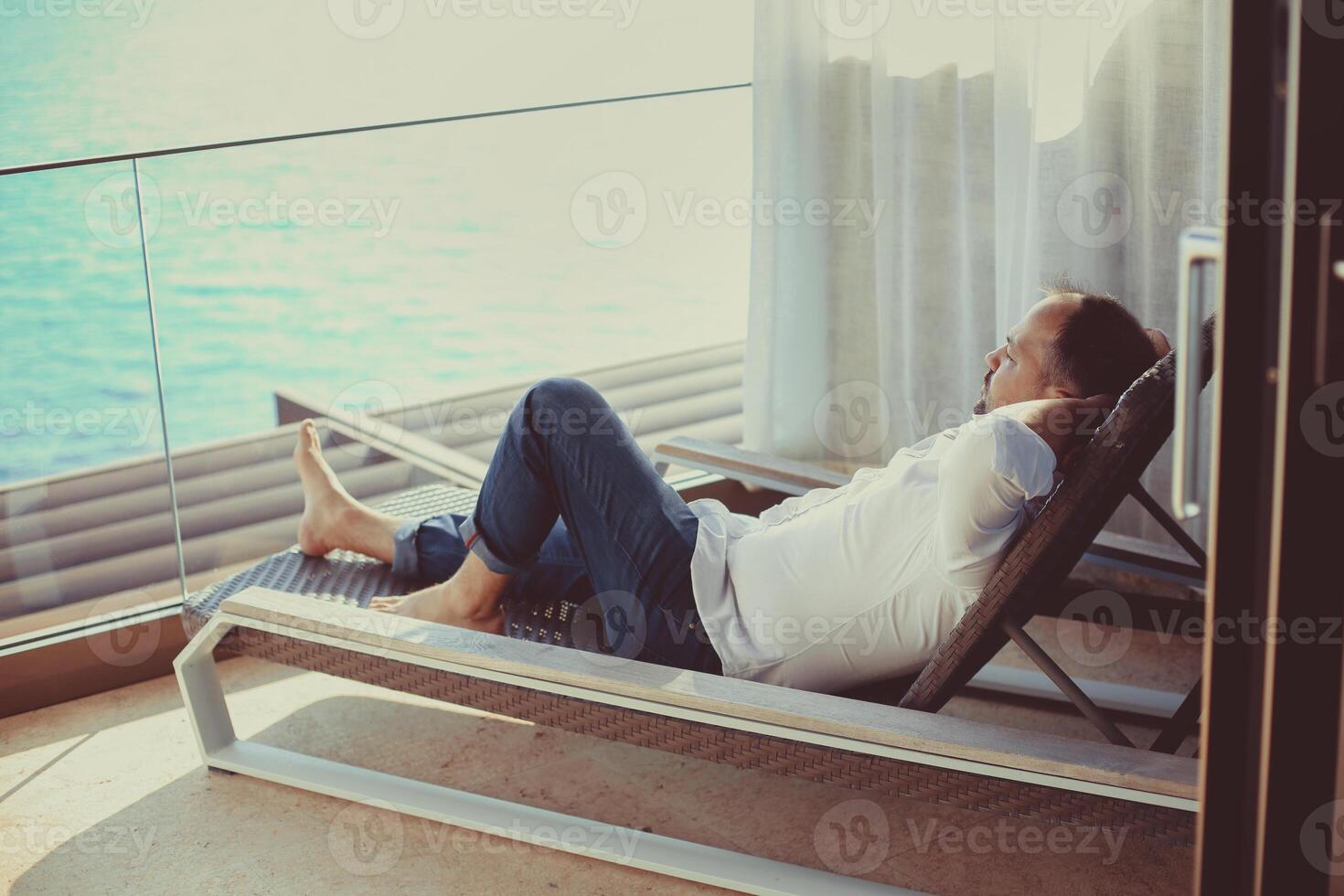 Relaxed young man at home on the balcony photo