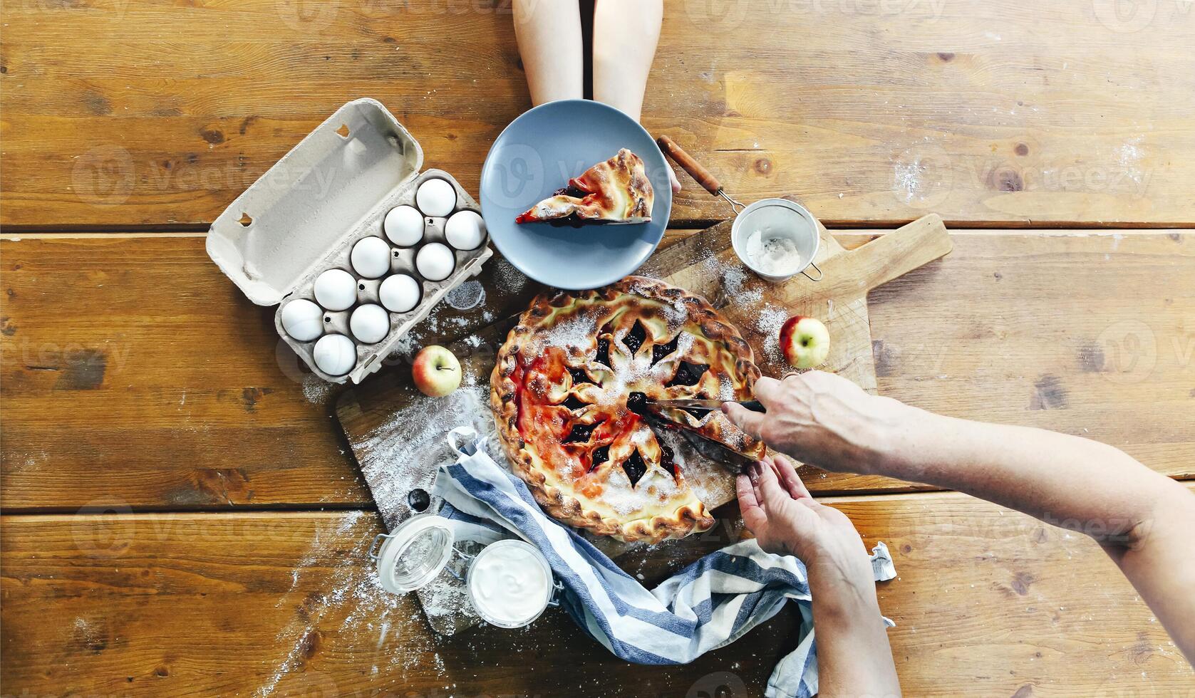 Crop person cutting pie on table photo