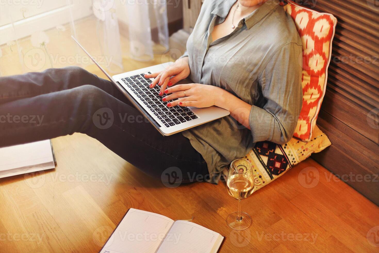 Crop freelancer with wine using laptop photo