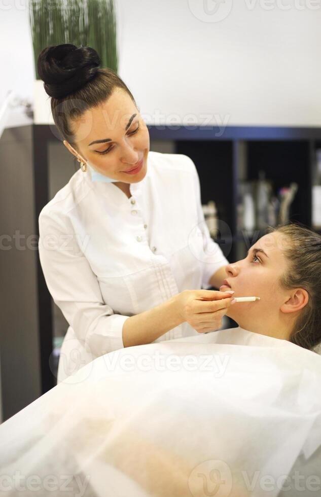 Female cosmetician working with client photo