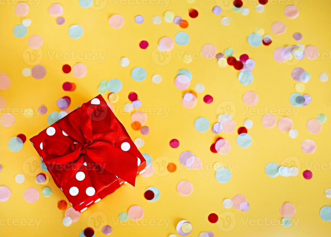 rojo regalo caja y vistoso papel picado en amarillo antecedentes foto