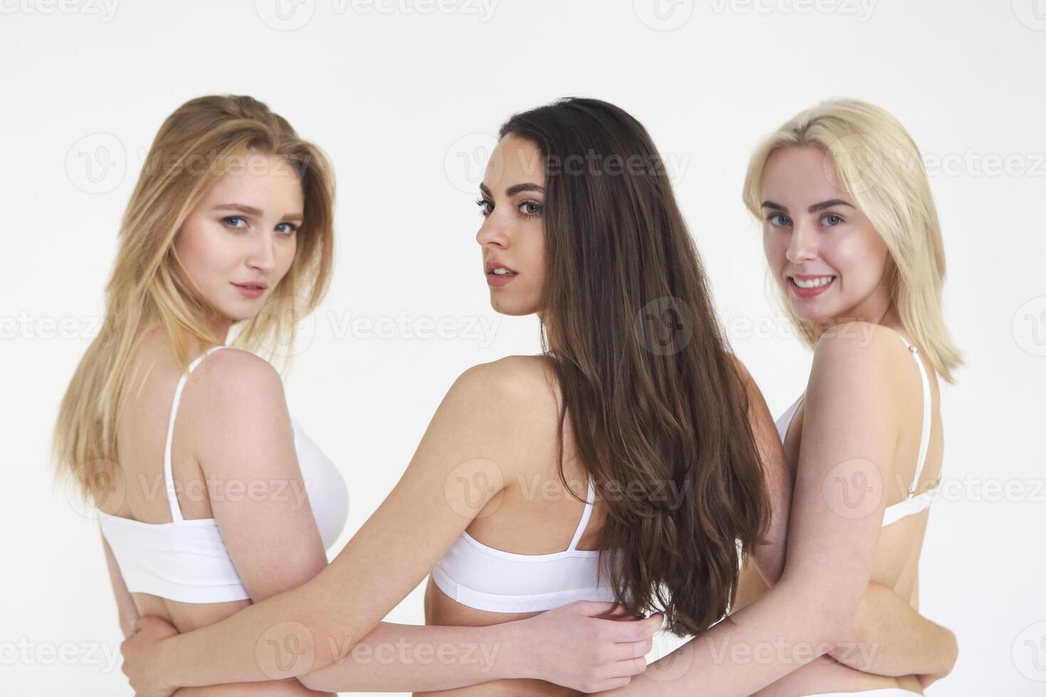 Cheerful young multiethnic women in white lingerie together photo